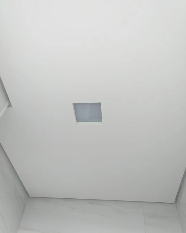 Casa na Península dos Pássaros, em Alphaville: teto de gesso liso e branco com um alçapão quadrado, visto de baixo